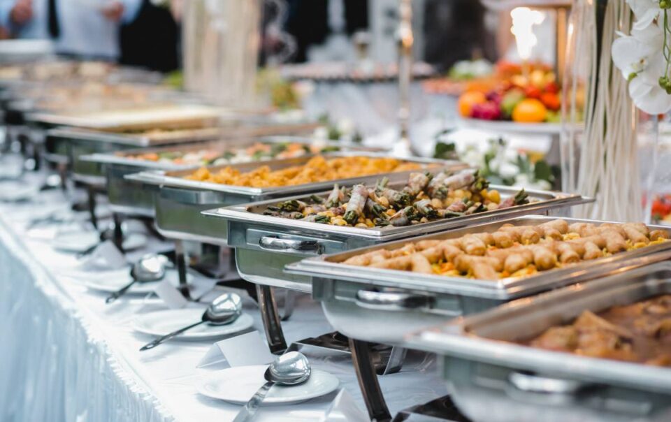 A table featuring warming platters of food for an event at a venue with catering packages near Southfield, MI