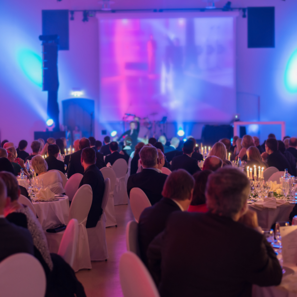 Gala event venue near Detroit, MI, featuring guests enjoying dinner and live performances with multi-colored lighting