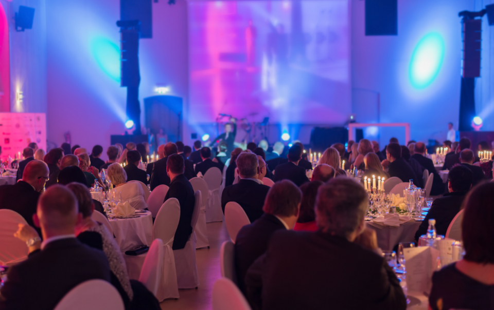 Gala event venue near Detroit, MI, featuring guests enjoying dinner and live performances with multi-colored lighting