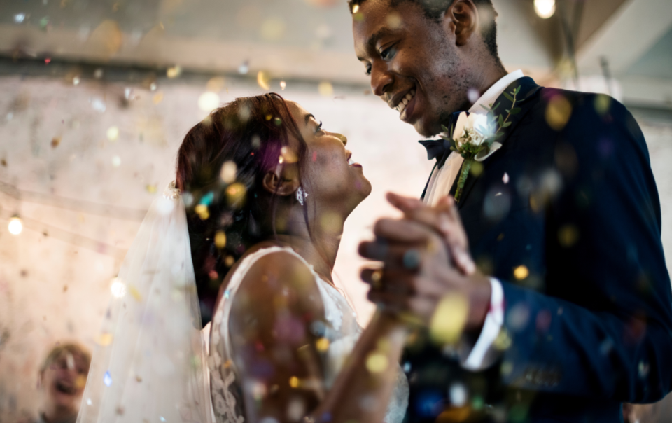 Beautiful bride and groom sharing a dance together with confetti on their wedding day